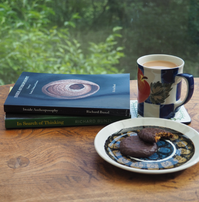 two books with a plate of bisuits and a cup of coffee